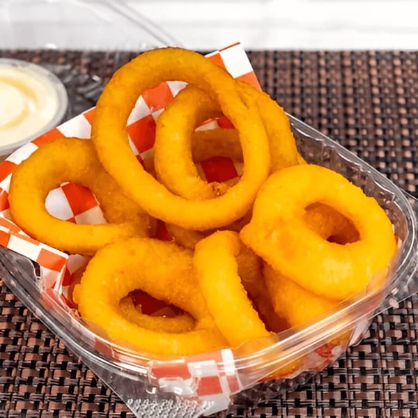 Golden-brown onion rings in a clear plastic container with a red and white checkered paper liner.