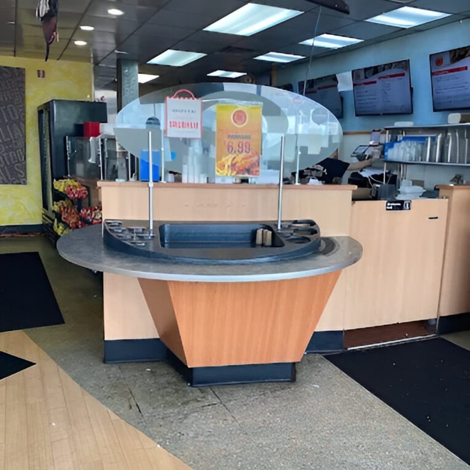 Interior view of AlBasha Subs, showing a condiment station, menu boards, and a counter.