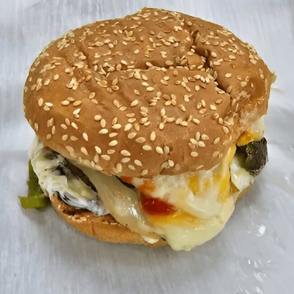 AlBasha Subs' burger with melted cheese, onions, and sauce on a sesame seed bun.