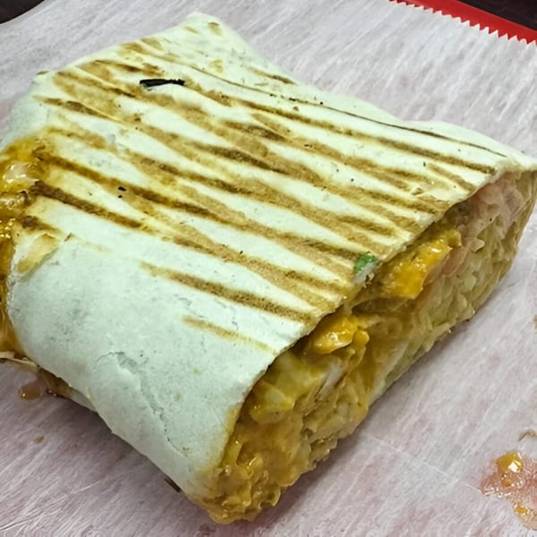Grilled AlBasha chicken sub-sandwich with melted cheese and grill marks on a white paper.